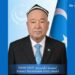 Ahmet Igemberdi | Шәрқий Түркистан Почтиси Commemorative poster honoring Ahmet Igemberdi (1937–2026); man in suit and blue tie with a Turkish flag in the background.